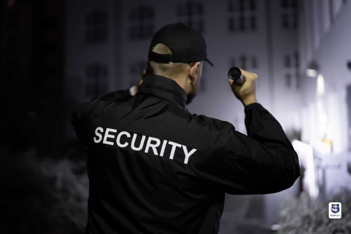 Security officer on patrol with flashlight at night